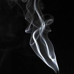Abstract white smoke swirls pattern over the black background