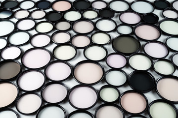 Glass round filters of different colors and sizes on a light background..