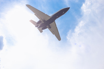 Fototapeta na wymiar Close-up of a passenger plane flying against a blue sky