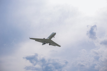 Close-up of a passenger plane flying against on the background of a stormy sky and clouds