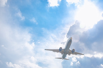 Fototapeta na wymiar Close-up of a passenger plane flying against a blue sky