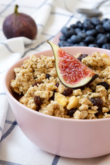 Pink bowl of fruit granola with fruits  ready to eat, side view. Close-up.