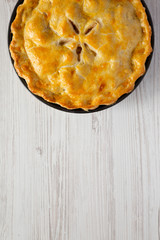 Homemade apple pie on a white wooden surface, top view. Flat lay, overhead, from above. Copy space.