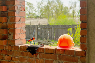 A pair of gloves and a Mason's helmet at the construction.