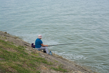 Fototapeta na wymiar Woman fishing on shore