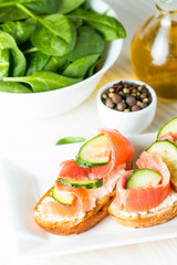Salmon, cucumber and cream cheese bruschetta. Italian tapas, antipasti with vegetables, herbs and oil on grilled ciabatta and baguette bread. Sandwich.