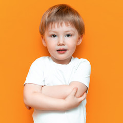 cheerful little boy child standing isolated over yellow background. Looking camera. with blonde hair mixed race central Asian and german