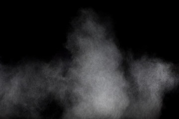 Bizarre forms of white powder explosion cloud against black background.White dust particles splash.