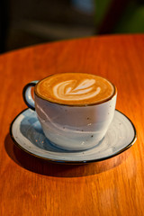 Cup of cappuccino on brown wooden table shot with copyspace