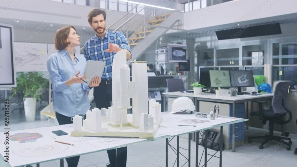 Poster in architectural bureau: architect and engineer talking, working on a building complex prototype pro