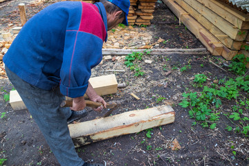 Master carpenter professionally working with an ax