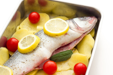Fish with lemon potatoes and tomatoes ready for the oven