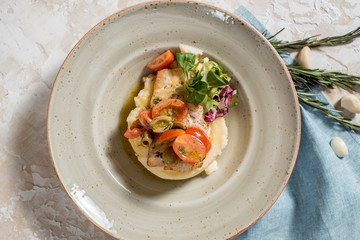 mashed potatoes, baked white fish, fresh, sauce and tomatoes. restaurant menu.