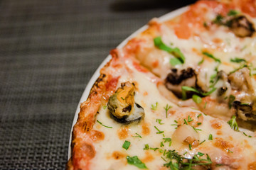 Pizza with seafood with melted cheese and herbs sprinkled on top