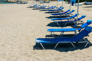 Sun beds, lounge chairs on the beach, on the seashore.