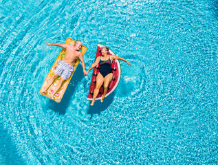 Above vertical view of people old senior couple taking hands with love and having fun on the blue...
