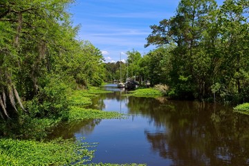 Fototapeta na wymiar Boats parked along a canal on a sunny spring day in Bayou De Zaire located in Madisonville, Louisiana