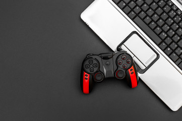 Gamepad with laptop on black background. Top view. Copy space.