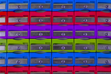 The concept of holidays in school. Texture of multicolored pencil sharpeners, close-up, flat lay with space for text