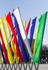 colored holiday flags on the background of the blue sky over the city