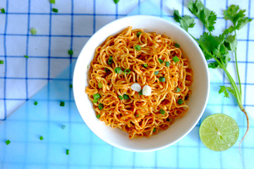 Dried instant noodle on white ceramic bowl on tablecloth