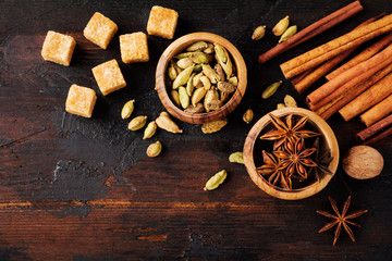 Set of spices of star anise, cardamom, cinnamon and brown sugar on old wooden background. Flat lay