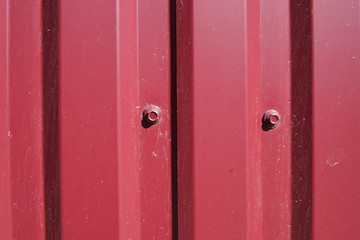 Fototapeta premium Background striped red metal profile. Texture of painted red metal surface