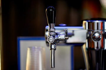 Tap in the bar for pouring drinks and beer. Closely. Luster of metal.