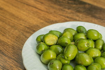 olives in white bowl on wooden background. Spanish typical appetizer