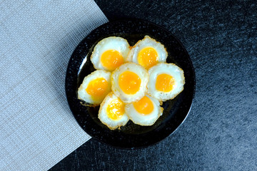 Fried quail egg on black background