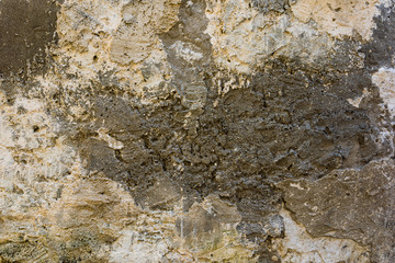 Old plastered textured wall with a multilayer cracked coating.