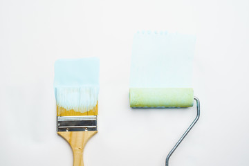 Photo of brush and roller with blue paint