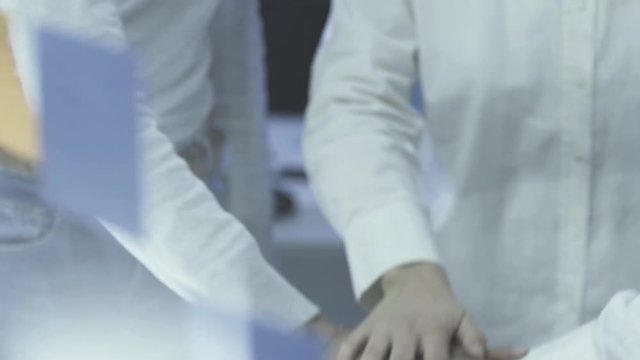 Cheerful business team stacking hands