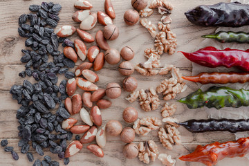 Raisins, brazilian nuts, macadamia nuts, walnut, and colorful traditoional georgian sweetness churchkhela on wooden background. Top view, flat lay. Horizontal image. 