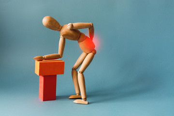 Concept of back pain. A wooden figure depicts a pain in the back.
