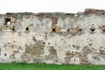 The high resolution texture of the old brick wall with showered plaster and clay putty with green...