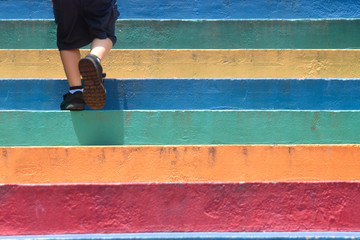 Lower part of a boy in casual shoe walking up outdoor colorful stair children lifestyle successful...