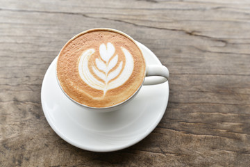 Coffee cup with latte art foam on wood table in coffee shop with copy space.Coffee is one of the most popular beverages.Improve Energy Levels and Burn Fat