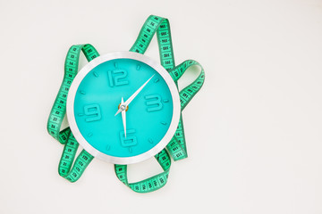 Clear glass of water for drinking on bed in the morning. Weight loss or diet concept. Alarm clock...