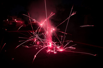 Action Photo of Red Fireworks Exploding on the Ground - with Embers Scattering in Multiple...