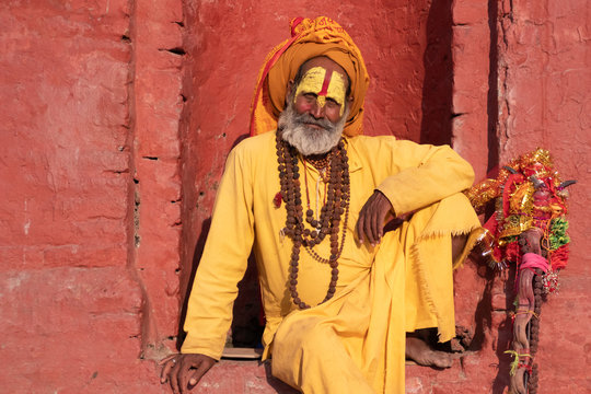 Kathmandu Sadhu men holy person in hinduism with traditional painted face at Pashupatinath Temple of Kathmandu - Non English word in image is prayer words - Powered by Adobe