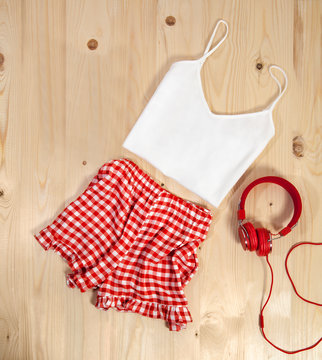 Women's red and white square patterned pajamas with red headset on wooden background - Image