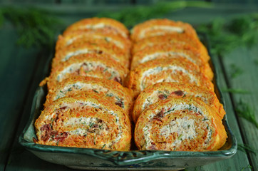 Sliced carrot roulade with cheese on a green platter
