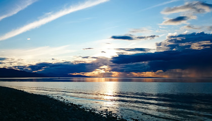 Obraz premium Sunset on Lake Baikal. Evening, rain, clouds, sun. Dramatic sky. Atmospheric landscape. The shore of Lake Baikal. Russia.
