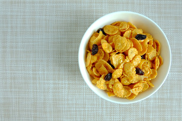 Corn flakes in white bowl on texture background