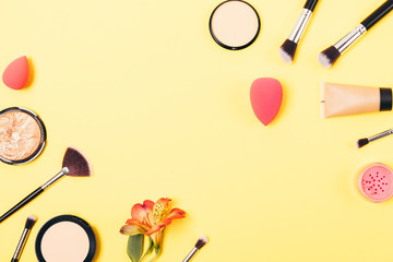 Bright yellow makeup background of cosmetics