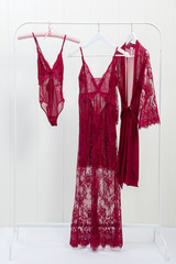 set of a pink nightgowns hanging on a rack on white background.