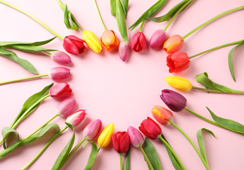 Heart made of beautiful tulip flowers on color background, flat lay. Space for text