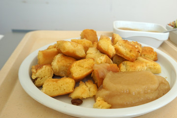 Sugared pancake with stewed plums with apple compote Fruit salad and green salad served on the tray