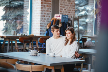 Pretty couple sitting in a cafe. Man and woman drinking a coffee